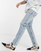 ASOS DESIGN – Schmale Jeans in heller Waschung mit Abnutzungen-Blau